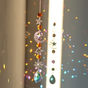 Primo piano di un acchiappasole in cristal con motivi celesti di luna, stella e sole.
