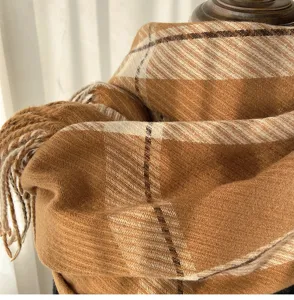 Close-up detail of a stylish brown plaid cashmere-feel tassel scarf, soft winter warmth.