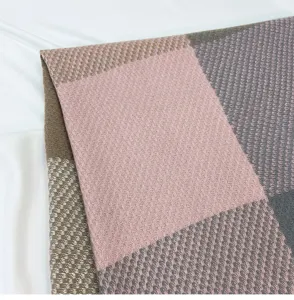 Close-up detail of a soft pink, brown and grey checkered winter scarf, showing fine knit texture.