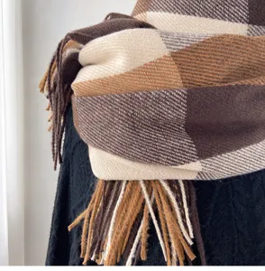 Detail view of a cozy brown and beige plaid imitation cashmere scarf with elegant fringe tassels.