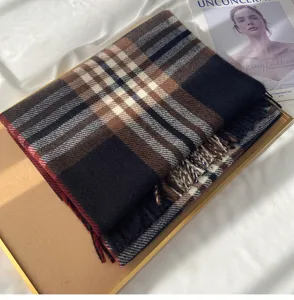 Detail shot of a classic British plaid imitation cashmere scarf with elegant fringe trim.