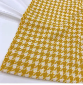 Close-up detail of yellow and white houndstooth winter scarf texture, soft fabric display.