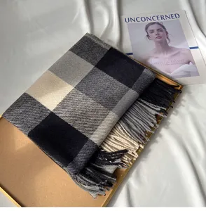 Detailed view of classic plaid scarf featuring soft cashmere-feel fabric and stylish fringe hem.
