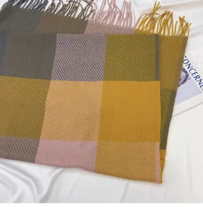 Detailed close-up of winter cozy plaid tassel scarf with soft multicolored fabric texture.