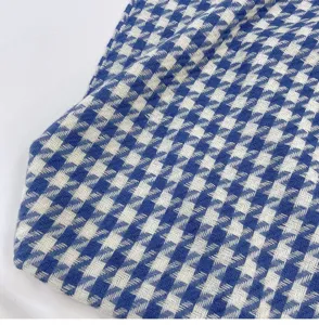 Close-up detail of a classic blue and white houndstooth winter scarf fabric texture.
