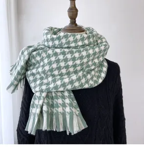 Close-up detail of the green and white houndstooth winter scarf with fringe trim texture.