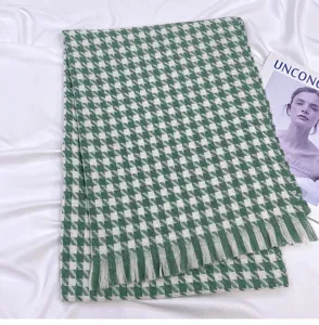 Detail view of the green houndstooth winter scarf, showing soft texture and fine tassel details.