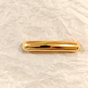 Gold minimalist curved spring hair clip for women, elegant metallic barrette for bun styling.