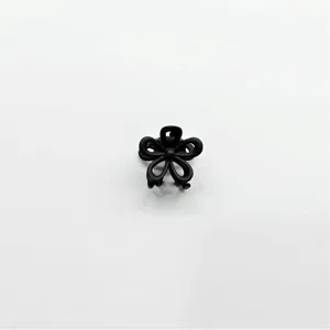 Detailed view of a black floral mini hair claw clip, perfect for styling hair securely.