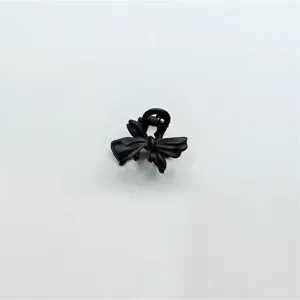 Detail shot of a black alloy mini hair claw clip featuring a cute bow design for hair.