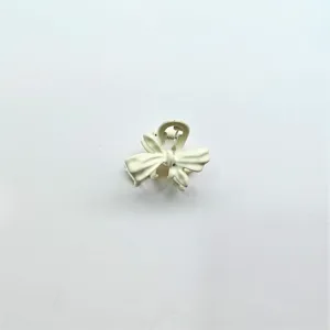 Detailed close-up shot showing the texture of the mini white bow hair claw clip.