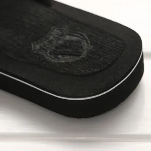 Detailansicht von Herren-Anti-Rutsch-Flip-Flops mit texturierter Sohle und weißem Streifen.