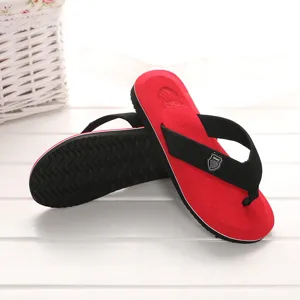 Detailansicht der rot-schwarzen Zehentrenner mit strukturierter Sohle und Riemendesign.