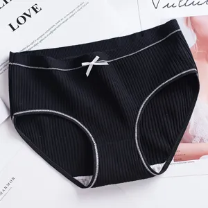 Vue détaillée de slips pour femmes en coton côtelé noir avec un joli nœud blanc.