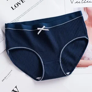 Vue détaillée de culottes pour femmes en coton côtelé bleu marine avec un nœud blanc délicat.