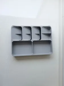 Detalle de organizador de cajón de cocina de plástico gris, bandeja de cubiertos