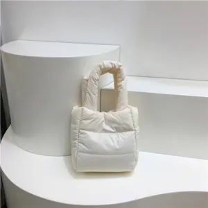 Gros plan sur la texture douce du sac matelassé, montrant des coutures nettes et du coton duvet.