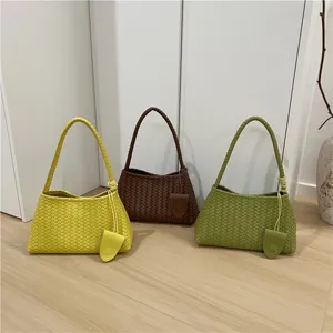 Detailed view of woven leather baguette shoulder bag in multiple vibrant colors, stylish.