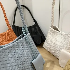 Chic woven leather shoulder bag, trendy baguette handbag with unique braided design.