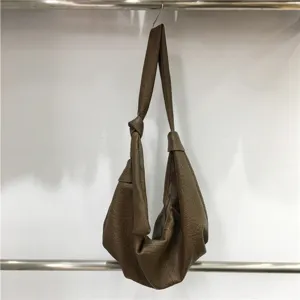 Detail view of the slouchy pleated brown hobo bag, showing soft leather texture and knot strap.