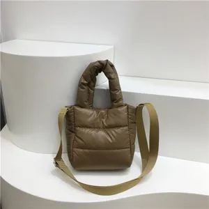 Gros plan détaillé du sac bandoulière matelassé marron, texture douce et sangle visibles.