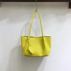 Yellow woven leather shoulder bag with double straps and heart charm for women mode.