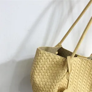 Chic yellow woven leather shoulder bag, trendy underarm tote with delicate woven texture detail.