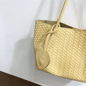 Detailed view of the soft leather woven shoulder bag, stylish yellow underarm tote design.