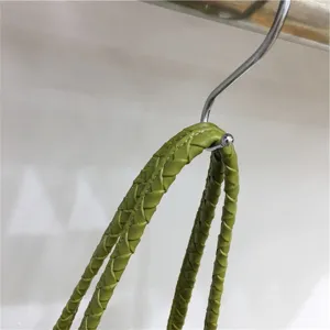 Green woven leather bag handle detail shot, stylish casual versatile shoulder tote bag for summer.