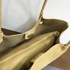 Yellow woven leather tote bag detail, soft shoulder handbag with inner zipper pouch.
