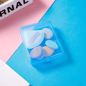 Detailed close-up view of transparent blue storage box with colorful makeup puffs inside.