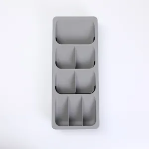 Organizador de cajones para cubiertos de plástico gris vista detallada compartimentos.
