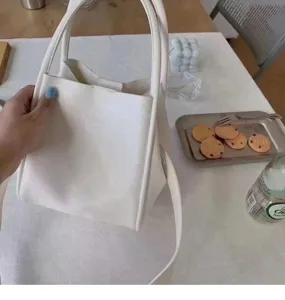 Minimalist white bucket bag detail showing soft leather texture and stylish shoulder strap.