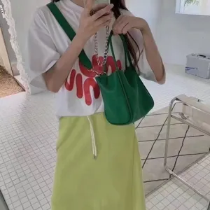 Green leather bucket bag handbag detail shot, fashionable Korean style shoulder bag design.