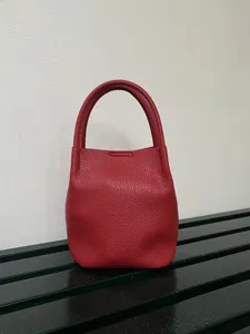 Vista dettagliata della borsa a secchiello in pelle rossa, borsa compatta ed elegante accessorio.