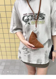 Mini brown soft leather croissant coin purse with lanyard, chic crescent dumpling bag detail.