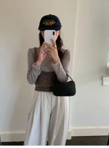 Detailed view of the stylish minimalist black handbag in a daily fashion outfit setting.