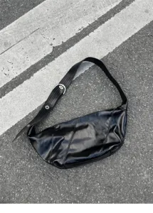 Detailed view of black oil-wax leather shoulder crossbody bag with wide strap and buckle.