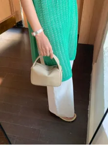 Detailed view of minimal handbag styled in daily outfit, showing smooth texture and shape.