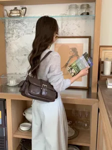 Vintage brown shoulder bag for women, multi-pocket design with chic buckle and comfortable strap.