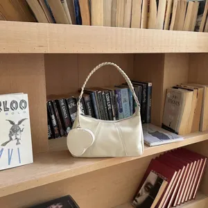 Borsa a tracolla in morbida pelle bianca con manico intrecciato e portamonete cuore.