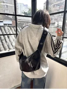 Detail view of black oil wax leather shoulder bag, soft slouchy dumpling croissant design.