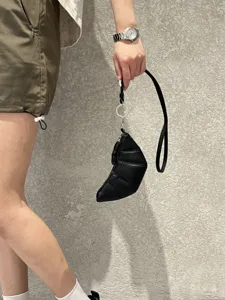Close-up detail of black soft leather croissant bag, featuring unique horn shape and lanyard.