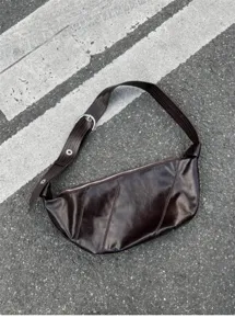 Detail view of the dark brown oil-wax leather croissant bag, showing soft texture and wide strap.