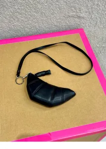 Black leather croissant coin purse with lanyard, compact mini half-moon bag detail view.