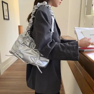 Trendy zilveren schoudertas met stijlvolle rimpels en een schattig strikdesign.