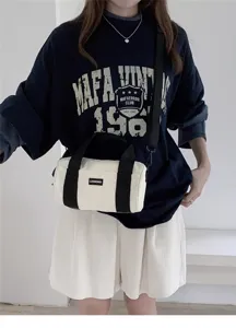 White canvas cylindrical shoulder bag detail, casual commuter style with black straps and label.