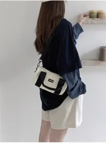 Detailed shot of casual canvas cylindrical shoulder bag with contrasting black straps and handles.