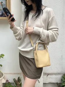 Vista dettagliata della mini borsa secchiello da donna a tracolla, mostra trama e cinghie.