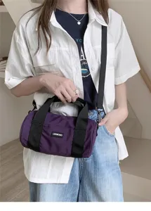 Detailed view of the purple nylon barrel shoulder bag with black handles and strap.